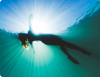 Kobieta leżąca w wodzie, ujęcie spod wody